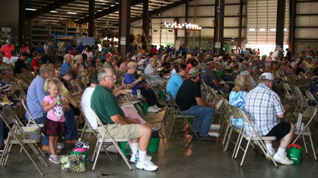 Crowd watches entertainment while enjoying dinner. 